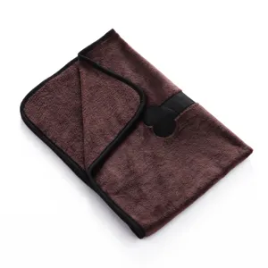 Soft brown pet blanket detail showing neat black binding and cute bone applique texture.