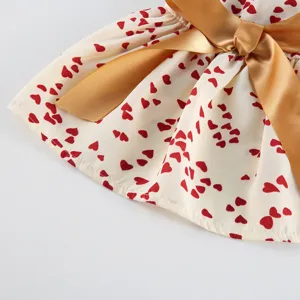 Cute pet dress detail with red heart prints and golden bow, perfect for summer daily wear.