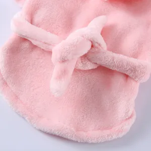 Close-up of soft pink fleece fabric and waist tie on a cozy pet bathrobe for dogs.