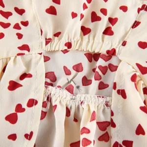 Pet dress clothing fabric detail close-up with cute red heart print and elastic stitching.