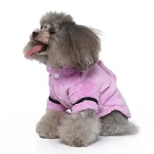 Side view of a small grey poodle wearing a soft pink plush pet bathrobe with hood and buttons