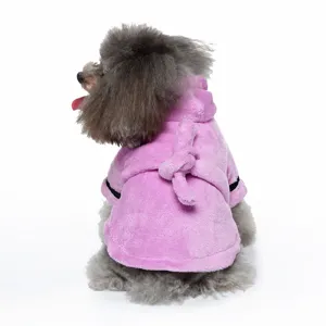 Back view of a small grey dog wearing a soft pink plush bathrobe with a hood and belt.