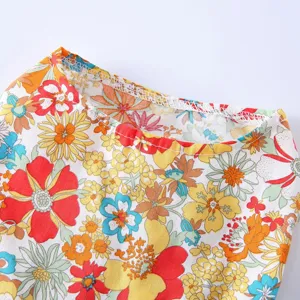 Gros plan de l'encolure de la robe pour animal avec un motif floral rétro vibrant sur un tissu léger.