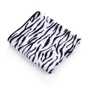 Close-up detail of soft black and white zebra pattern fleece blanket fabric texture.