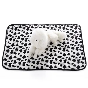 Soft plush pet blanket with black and white cow print, cozy fleece mat for dogs and cats.