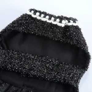 Détail robe de chien tissu scintillant noir élégant et col tissé blanc vue en gros plan