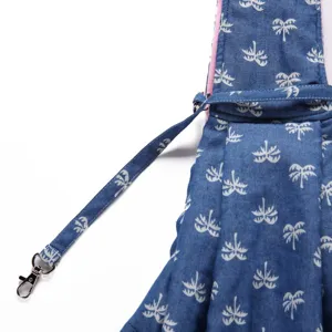Close-up detail of blue pet sling bag with print pattern, adjustable strap and metal hook.