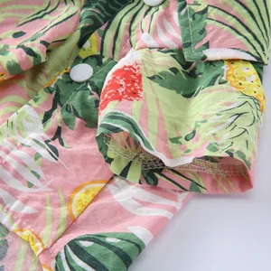 Nahaufnahme von tropischem Palmen- und Ananasdruck auf einem rosa Haustier-Sommerhemd