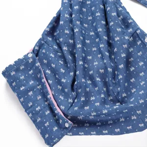 Blue bow heart print fabric detail of pet sling bag with pink lining and white snap buttons.