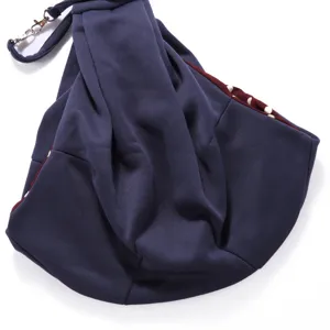 Breathable pet sling carrier bag with secure shoulder strap and polka dot inner lining.