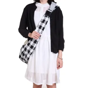 Breathable black-white checkered pet sling bag detail, comfortable outdoor carrier for dogs.