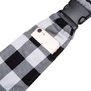 Pet carrier bag strap detail showing convenient pocket and durable black and white plaid fabric.