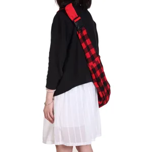 Red and black plaid pet sling bag detail view, comfortable strap and breathable fabric design.