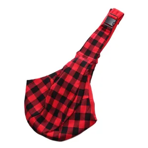 Detailed view of the red and black buffalo plaid pet sling bag showing fabric and strap.