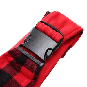 Detailed shot of pet bag strap with durable plastic buckle and red black plaid fabric.