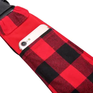 Pet carrier shoulder strap detail featuring red black plaid fabric, phone pocket and buckle.