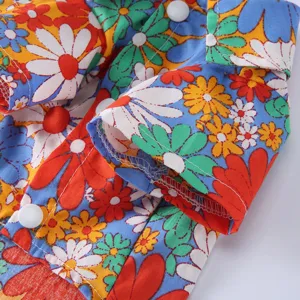 Detailaufnahme eines Haustier-Sommerhemdes mit lebhaftem Gänseblümchen-Blumenmuster und Nähten.