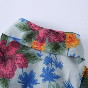 Nahaufnahme eines Tier-Sommerhemdkragens mit tropischem Hibiskus- und Palmenmuster.