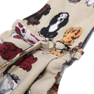 Detailed view of beige canvas pet carrier bag with cute dog prints and durable metal hardware.