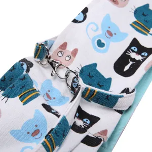 Canvas pet bag strap detail with cute cartoon cat print and metal hook for outdoor travel.