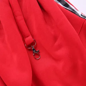 Close-up detail of red pet bag fabric featuring a durable metal hook and black white plaid.