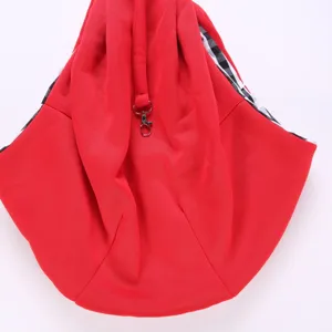 Detailed view of red pet shoulder sling bag with black and white plaid lining and metal clasp.
