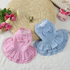 Detailed macro view of pink and blue checkered pet dresses with cute bow decorative accents.
