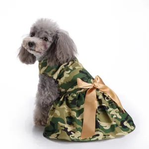 Back view of a dog wearing a camouflage dress with a golden satin bow detail.