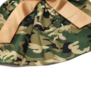 Close-up of camouflage pet skirt featuring a large tan satin ribbon bow detail.