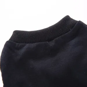 Gros plan détaillé du col d'un gilet unicolore noir pour chien, tissu tricoté.