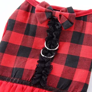 Primo piano dettaglio pettorina quadretti rosso nero fiocco pizzo vestito per cani.