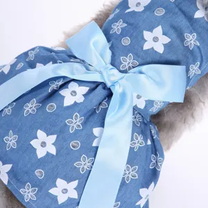 Nahaufnahme des blauen Haustierkleides mit Blumenmuster und großer Satinschleife aus Stoff.