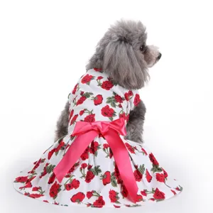 Detailed view of white floral pet dress with large pink satin bow and red rose print