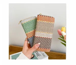 Close-up view of woven linen clutch bag with a stylish colorful plaid pattern.