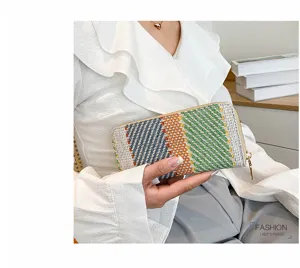 Close-up of a women's colorful woven linen clutch purse with gold zipper detail