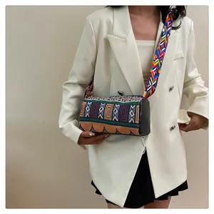Gedetailleerd overzicht van een kleurrijke canvas cilindertas in etnische stijl bij een model