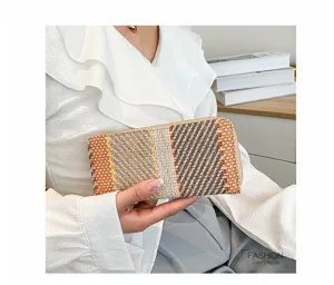 Detailed macro view of woven linen clutch bag featuring orange and beige checkered pattern