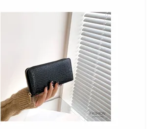 Primer plano de la elegante textura de cocodrilo negro en una cartera larga de cuero