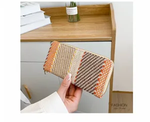 Woven linen clutch purse with multi-colored geometric pattern held by hand