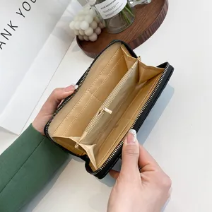 Innenansicht einer offenen, langen, bestickten Damenhandtasche mit Kartenfächern.
