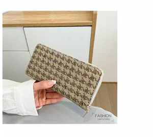 Detailed macro view of women's lattice pattern linen clutch bag with gold zipper.