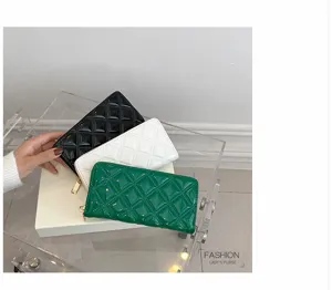 Detail view of stylish quilted patent leather long wallets for women in black white and green