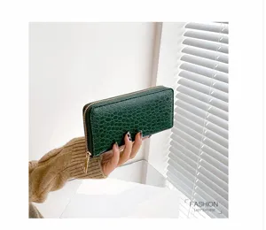 Detalle de la cartera larga para mujer en color verde con grabado de cocodrilo y cremallera