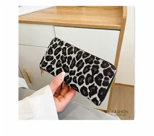 Detailed view of a stylish leopard print women's long clutch wallet held by hand.