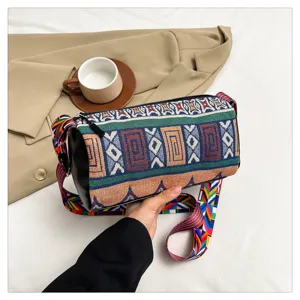 Detail van canvas tonvormige tas in etnische stijl met gekleurde riem