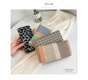 Close-up detail of stylish linen woven long wallets with various patterns and zip closure.