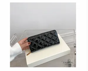 Detailed macro view of a glossy black quilted long wallet for women being held by hand