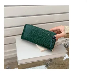 Vista detallada de una cartera larga de mujer con relieve de cocodrilo verde y cremallera