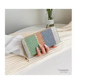Woven linen striped clutch bag for women held by hand
