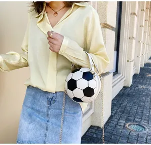 Elegante bolso con forma de balón de fútbol y cadena dorada mostrado en modelo